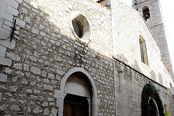 A stone building with a window and a bell tower