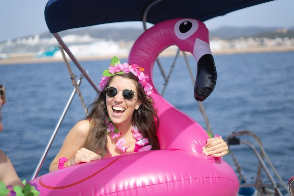 A woman is sitting in a pink flamingo float