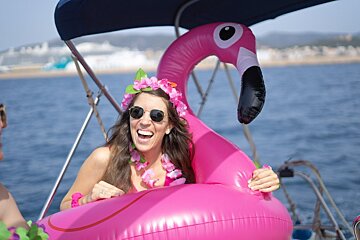 A woman is sitting in a pink flamingo float