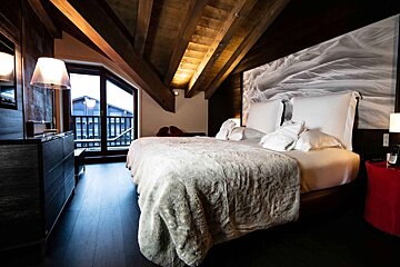 A bedroom with two beds and a large window