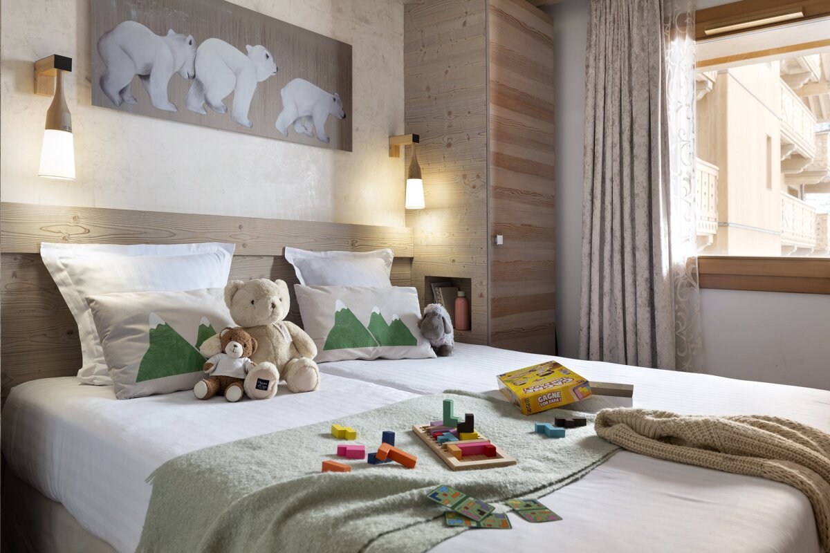 A bedroom with a monopoly game on the bed