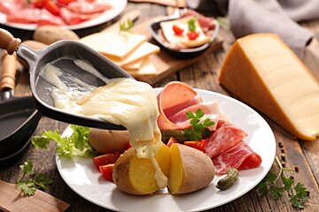 Cheese is being poured into a potato on a plate
