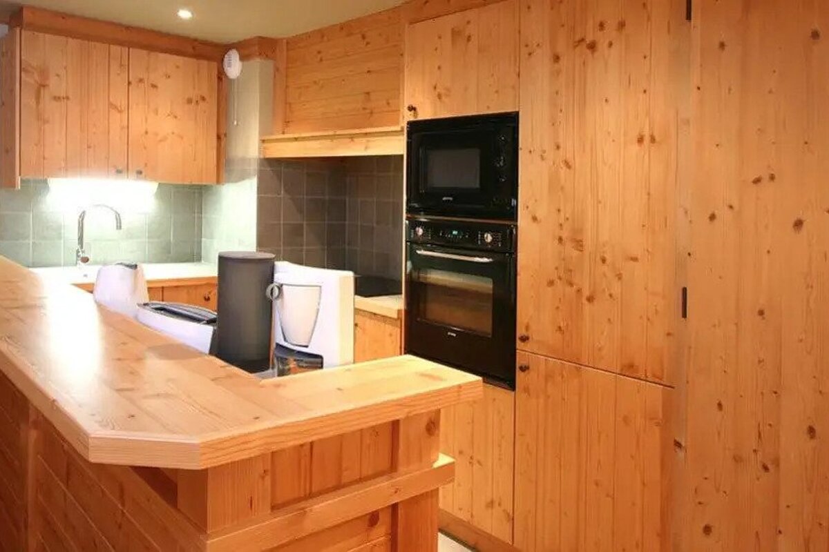 A kitchen with wooden cabinets and a black oven