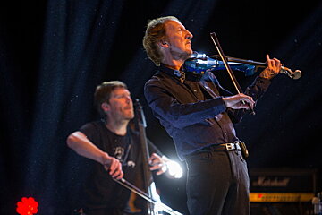 A man playing a violin in front of a marshall amplifier