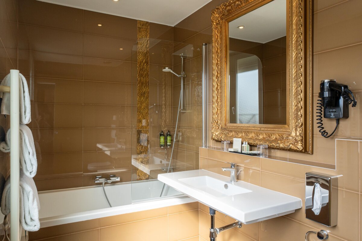 A bathroom with a bathtub a sink and a mirror