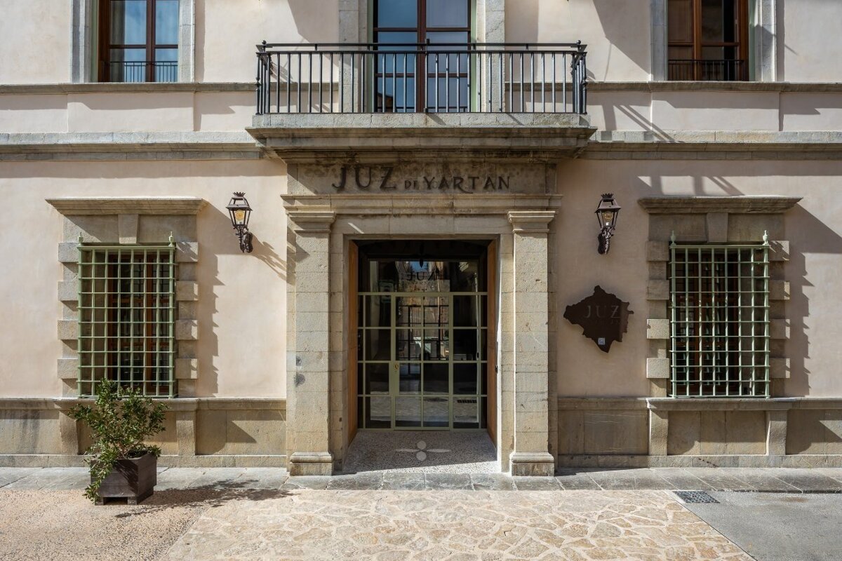 A beige building facade featuring an ornate stone entrance with