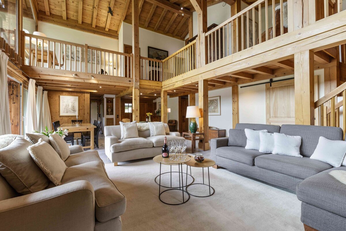 A living room with two couches and a table with a bottle of champagne on it