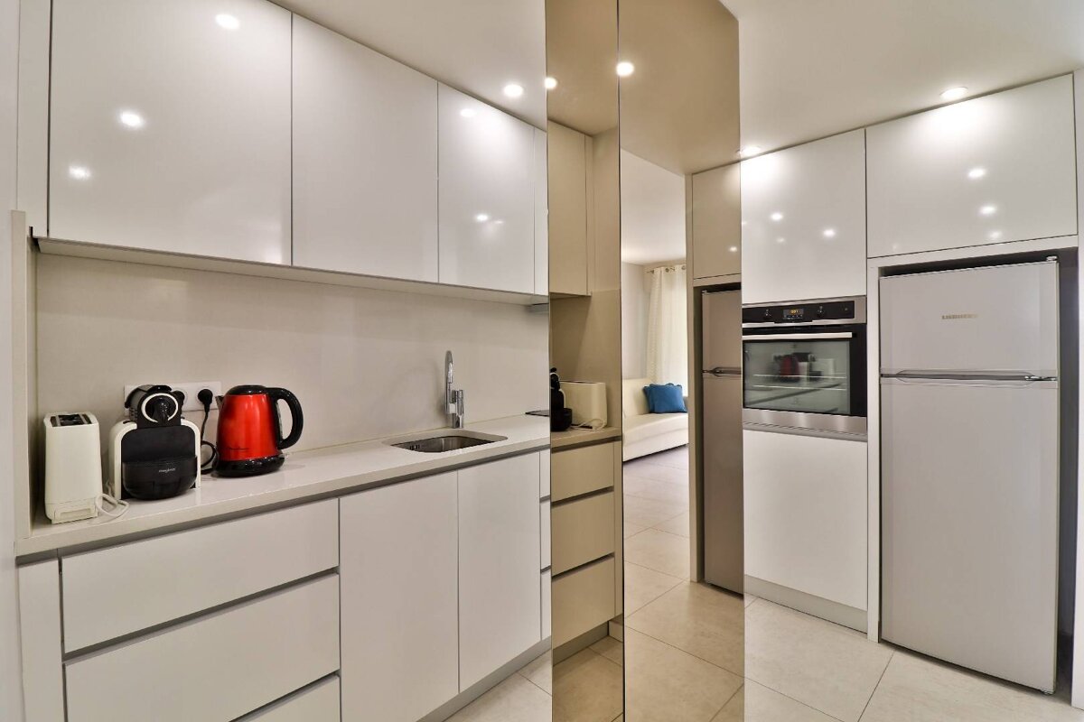 A kitchen with white cabinets and a bosch refrigerator