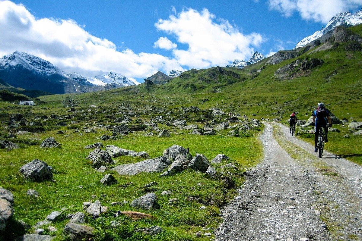 People riding bikes down a dirt road in the mountains