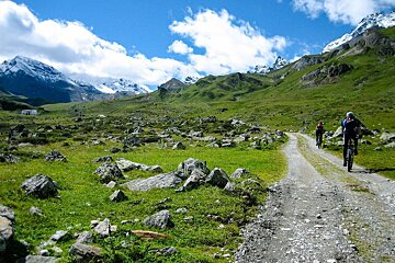 People riding bikes down a dirt road in the mountains