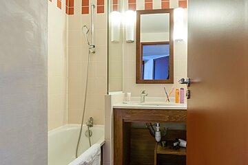 A bathroom with a bathtub sink and mirror