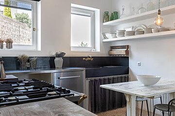 A kitchen with a stove top oven and a sink