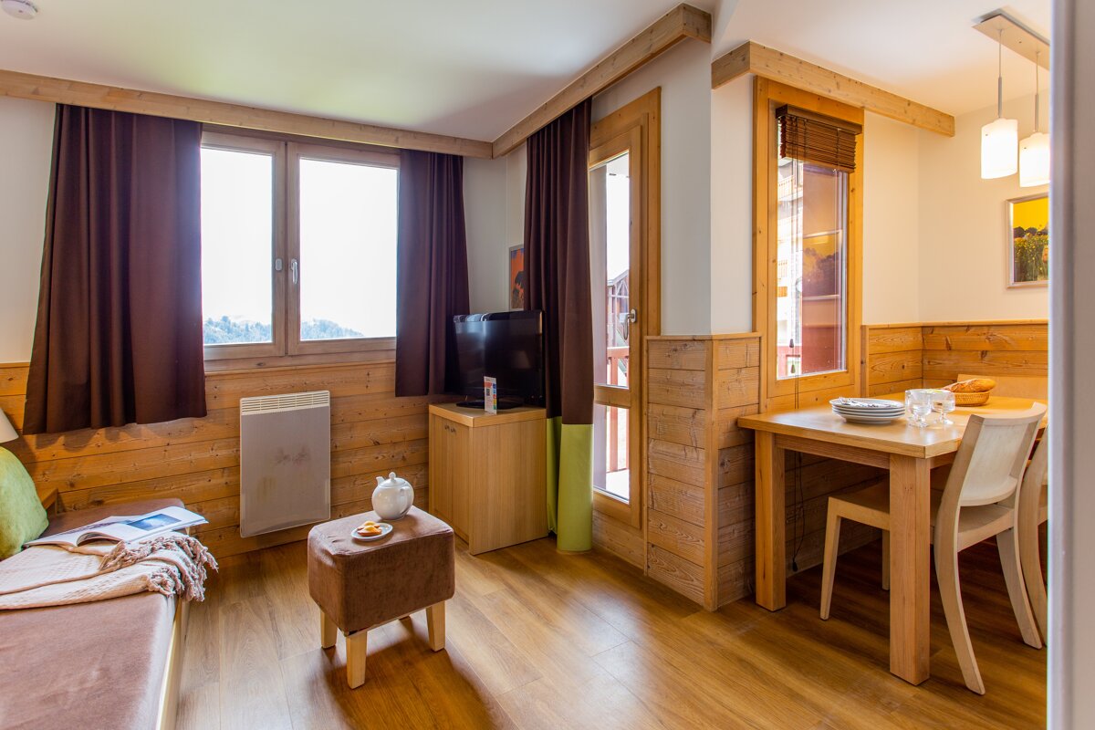 A living room with a table and chairs and a television