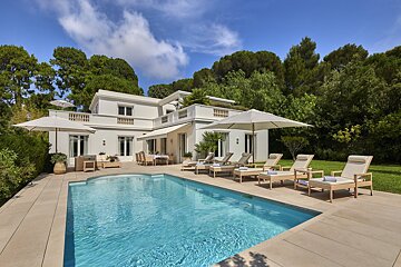 A large white house with a swimming pool in front of it