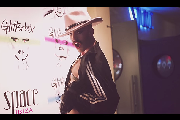 A man in a cowboy hat stands in front of a wall that says space ibiza