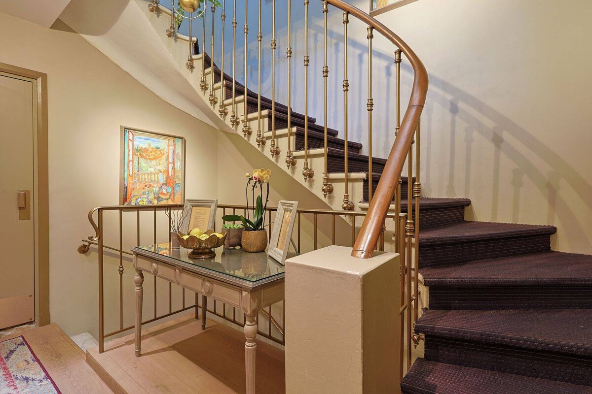 A staircase with a painting on the wall above it