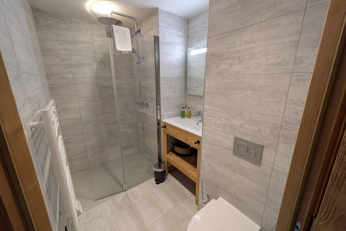 A bathroom with a walk in shower and a toilet