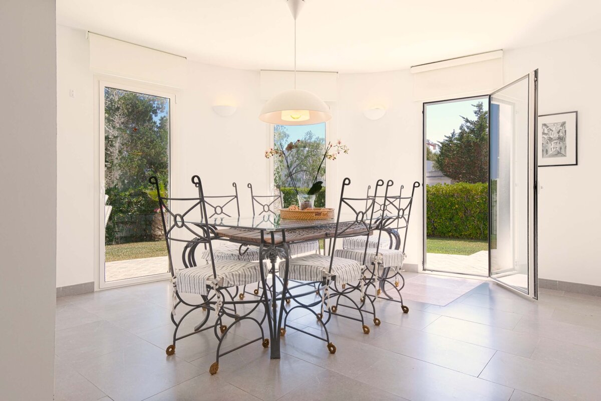 A white dining room with a table and chairs