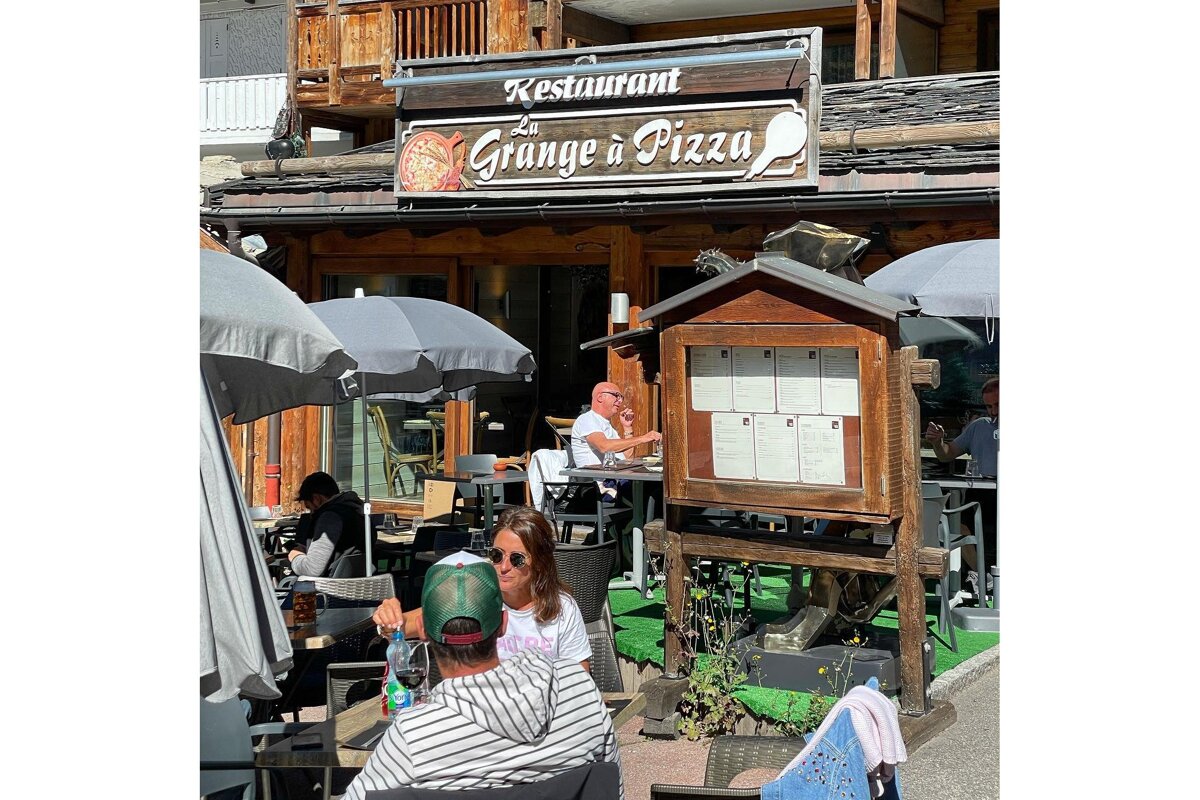 A restaurant called la grange a pizza with people sitting outside