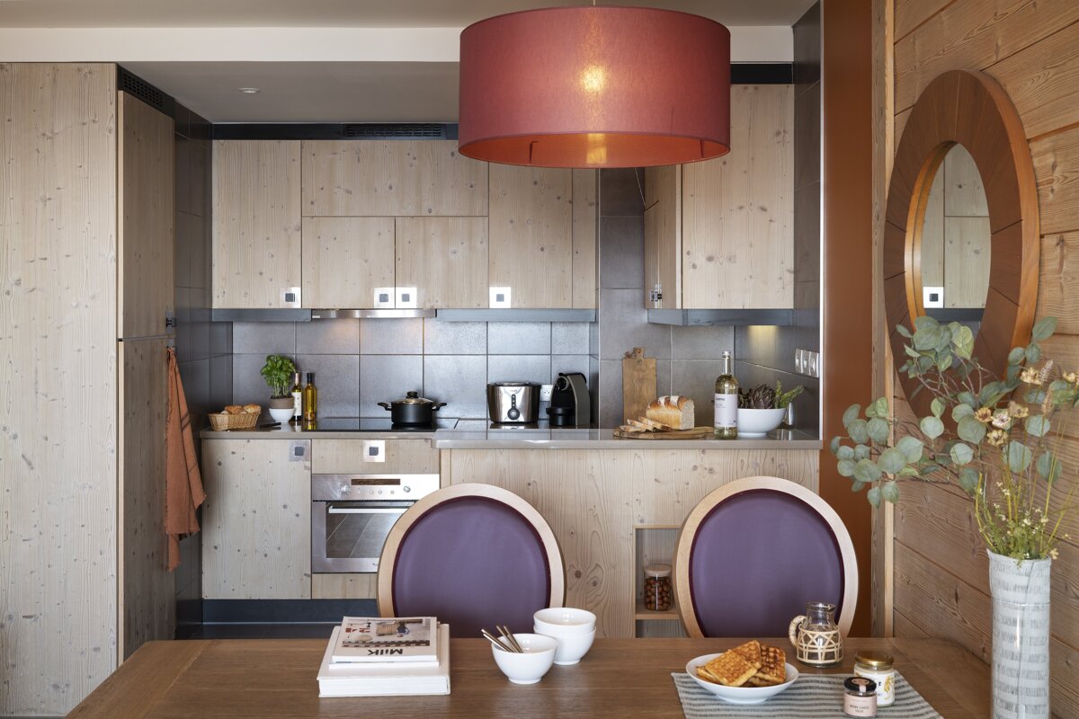 A kitchen with wooden cabinets and a red lamp