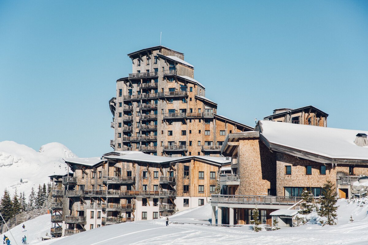 A large building with a lot of balconies is covered in snow