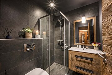 A bathroom with a walk in shower and a sink