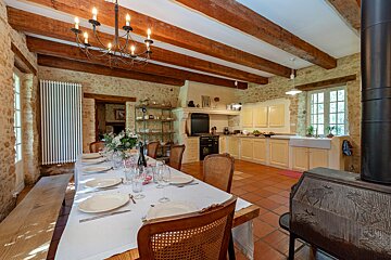 A long table with plates and glasses on it in a kitchen