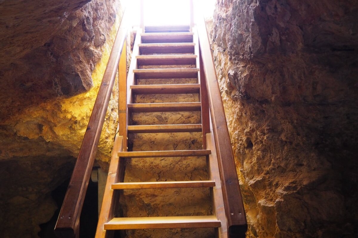 a ladder leading down into the Necropolis cave in Ibiza town