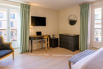 A room with a desk and chair and a flat screen tv