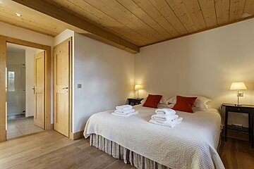 A bedroom with a king size bed and two lamps