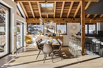 A dining room with a long table and chairs