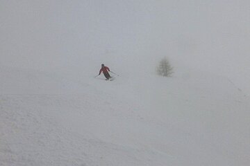 a man in red skiing in fog
