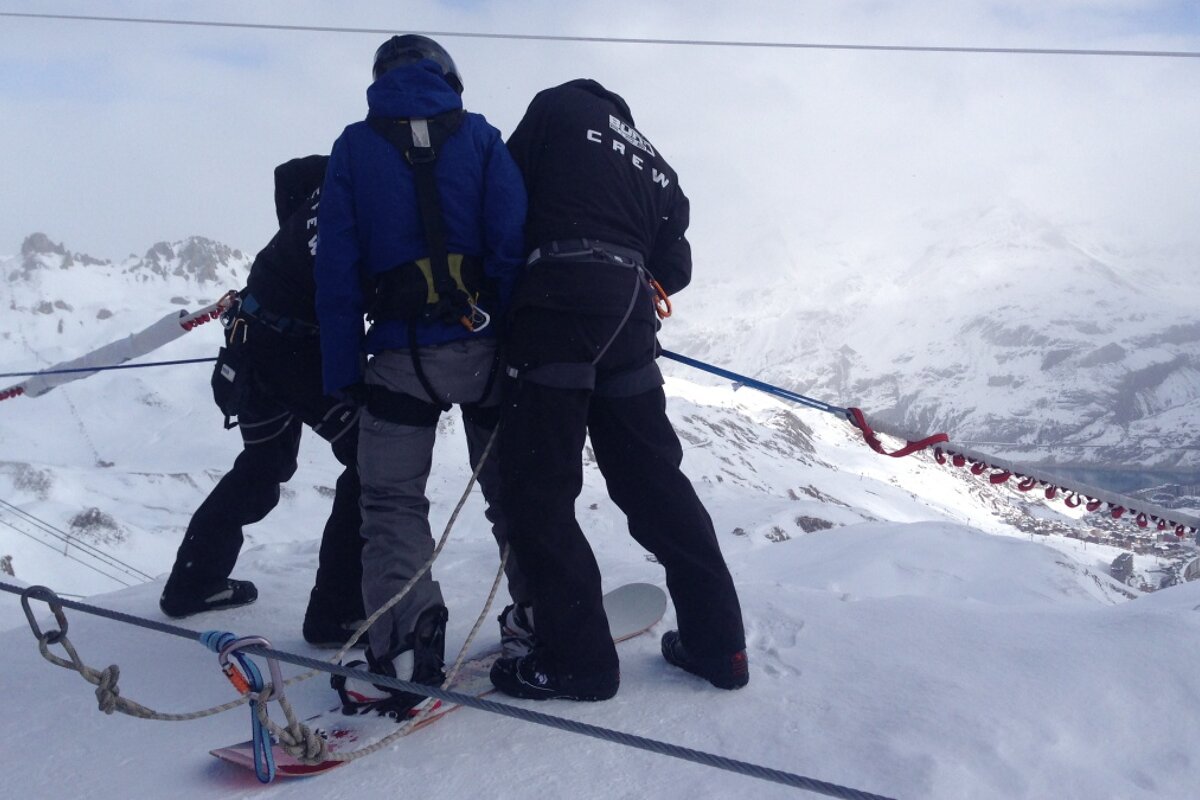 a woman being connected in a harness before the ski jump