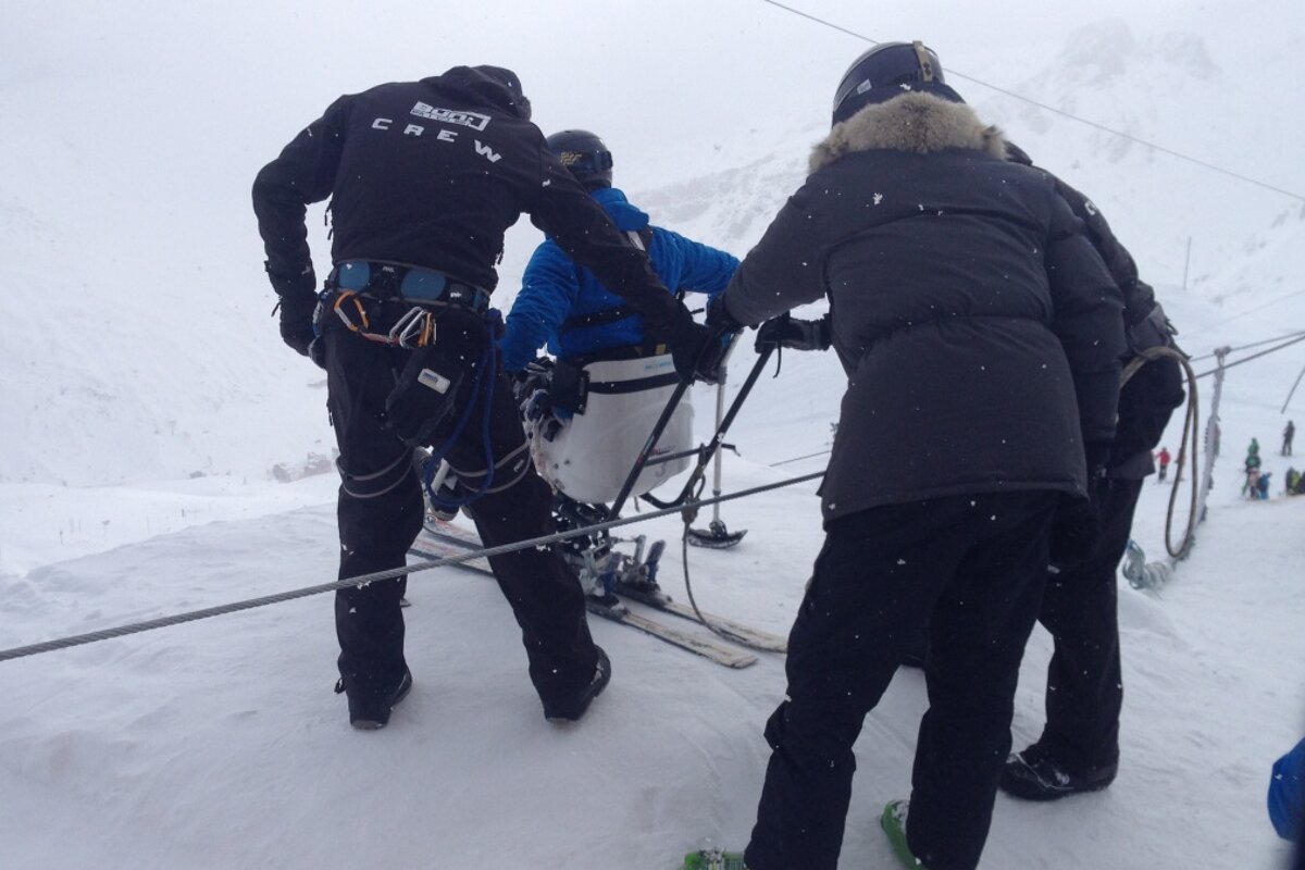 a man in a sit ski about to do a ski jump