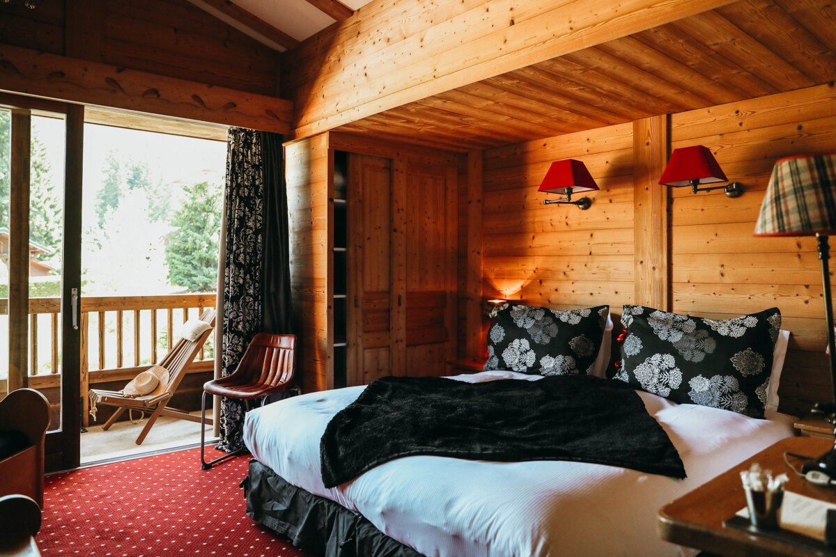 A wooden room with a bed and a chair