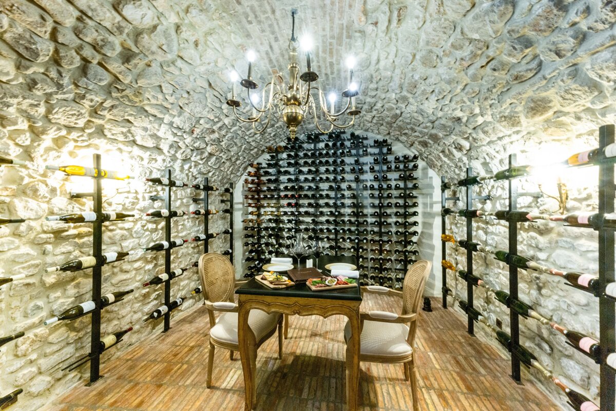 A wine cellar with a table and chairs and a chandelier