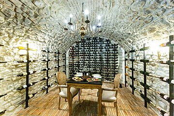 A wine cellar with a table and chairs and a chandelier