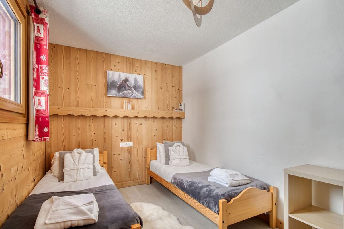 A bedroom with two beds and a painting on the wall