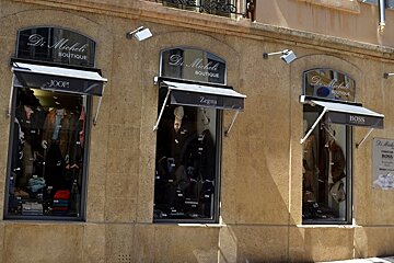 Image of a store front with black canopys and displays in the windows