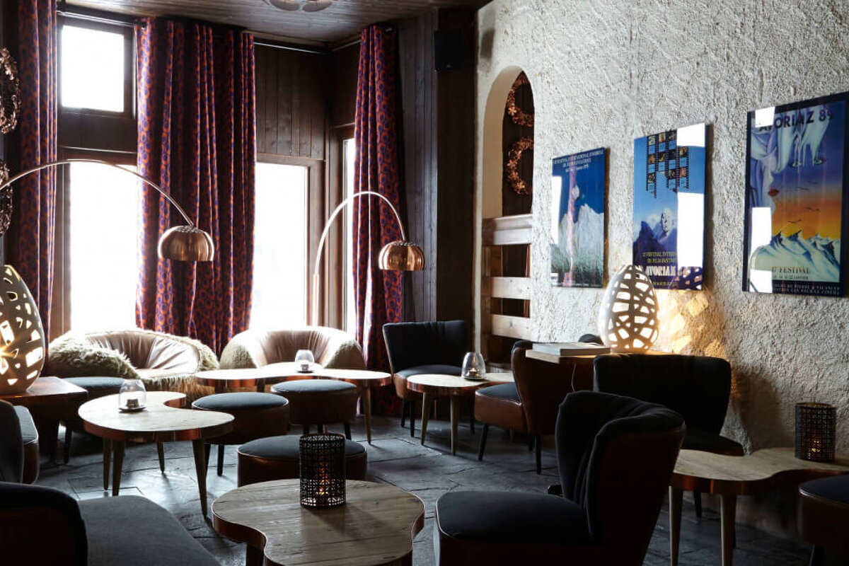 A room with a few tables and chairs and posters on the wall