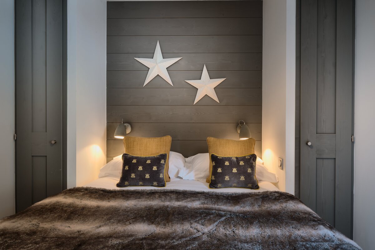 A bedroom with two stars on the wall above the bed