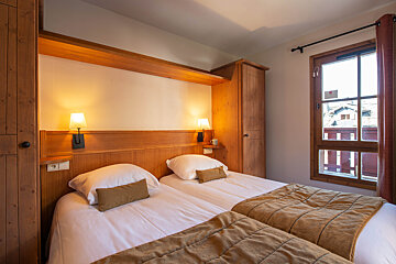 A hotel room with two beds and a window