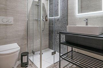 A bathroom with a toilet a sink and a shower