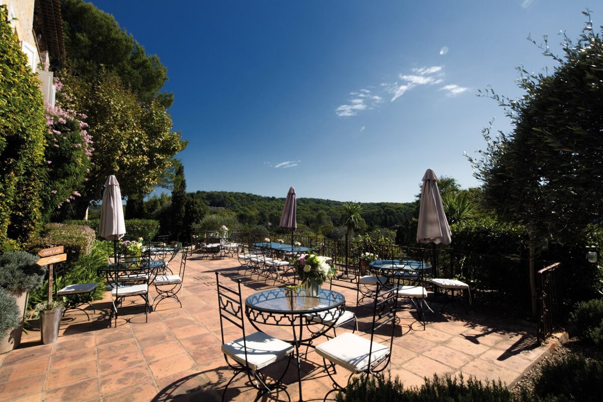 A patio area with tables and chairs and umbrellas