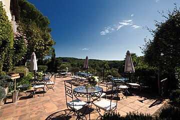 A patio area with tables and chairs and umbrellas