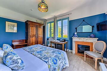 A bedroom with blue walls and a fireplace