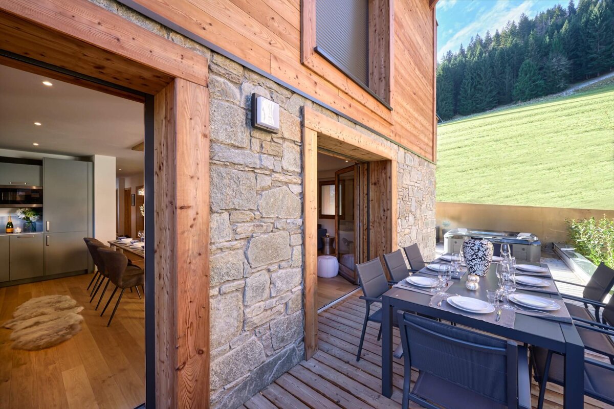A wooden house with a table and chairs outside