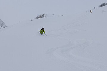 a skier with two people up slope from him