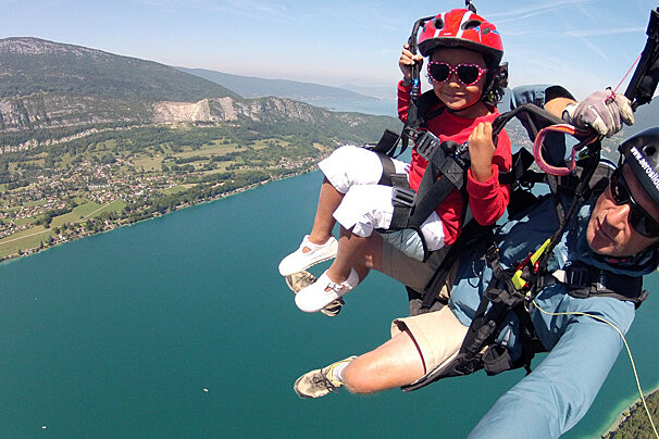 a child with a parapente tandem instructor