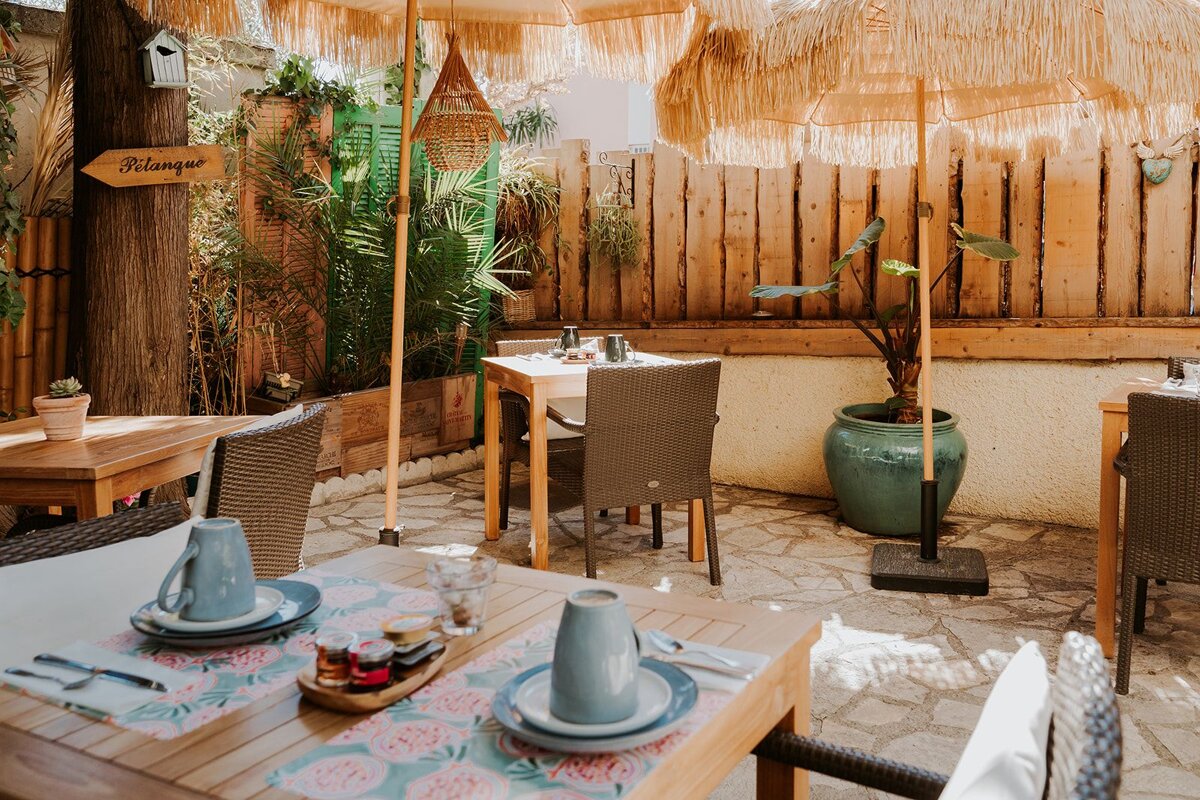 A patio with tables and chairs and a sign that says pitango